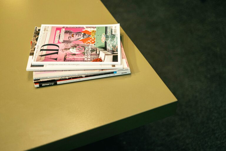 A neat stack of colorful magazines on a modern table with a minimalistic design.